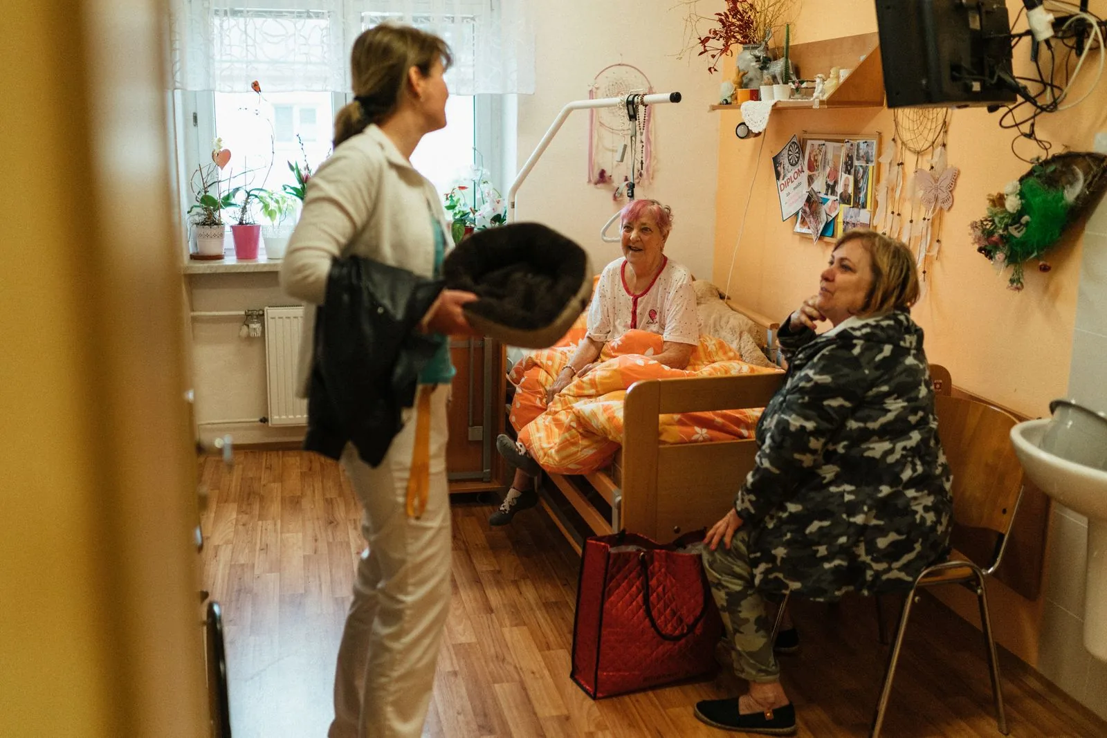A caregiver speaking with older women in a nursing home